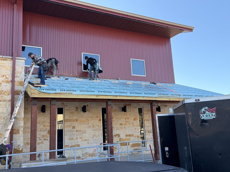 Crew re-decking a metal building roof in Bandera County