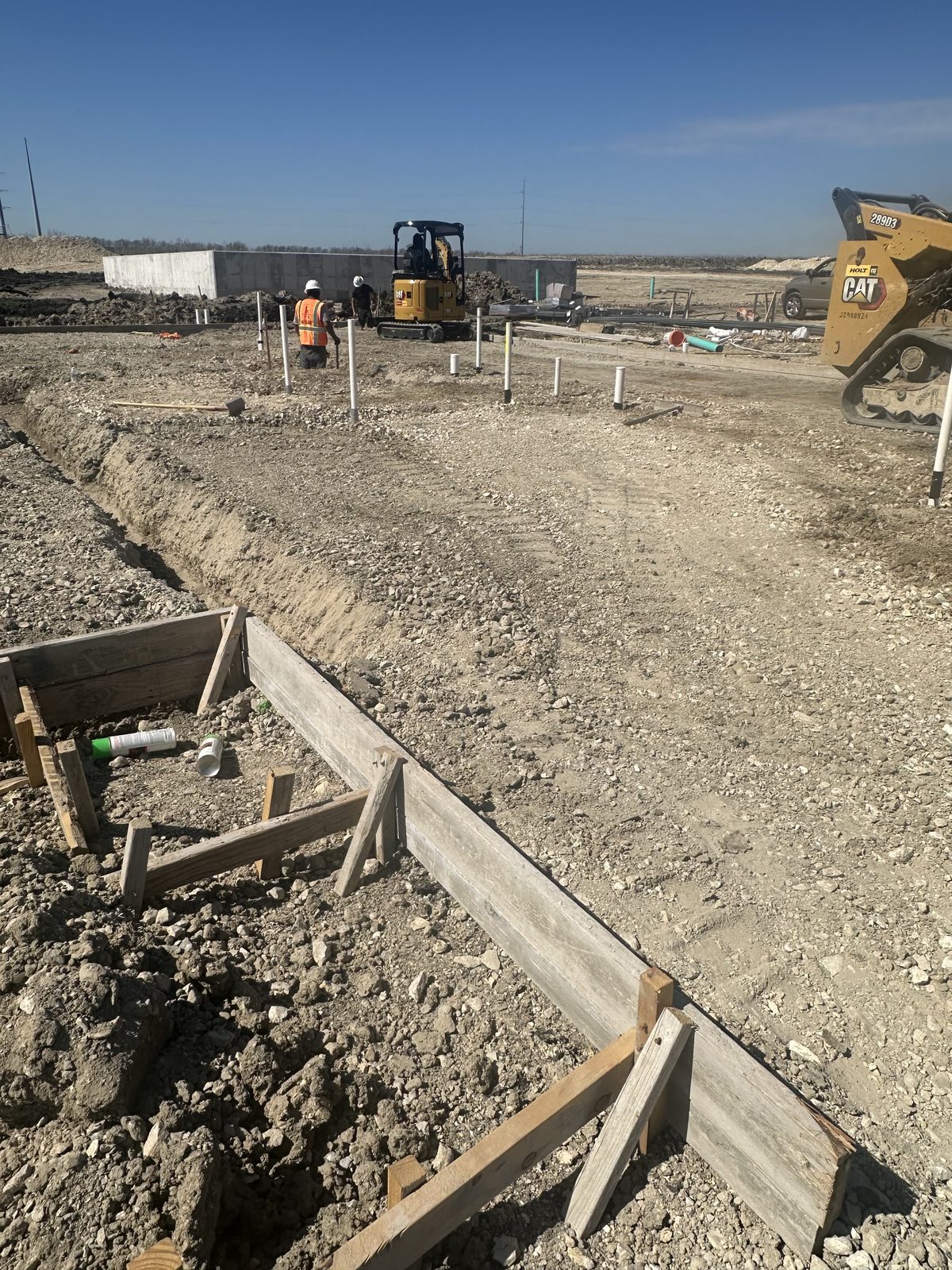 Grade beam forms and under-slab plumbing at a foundation site