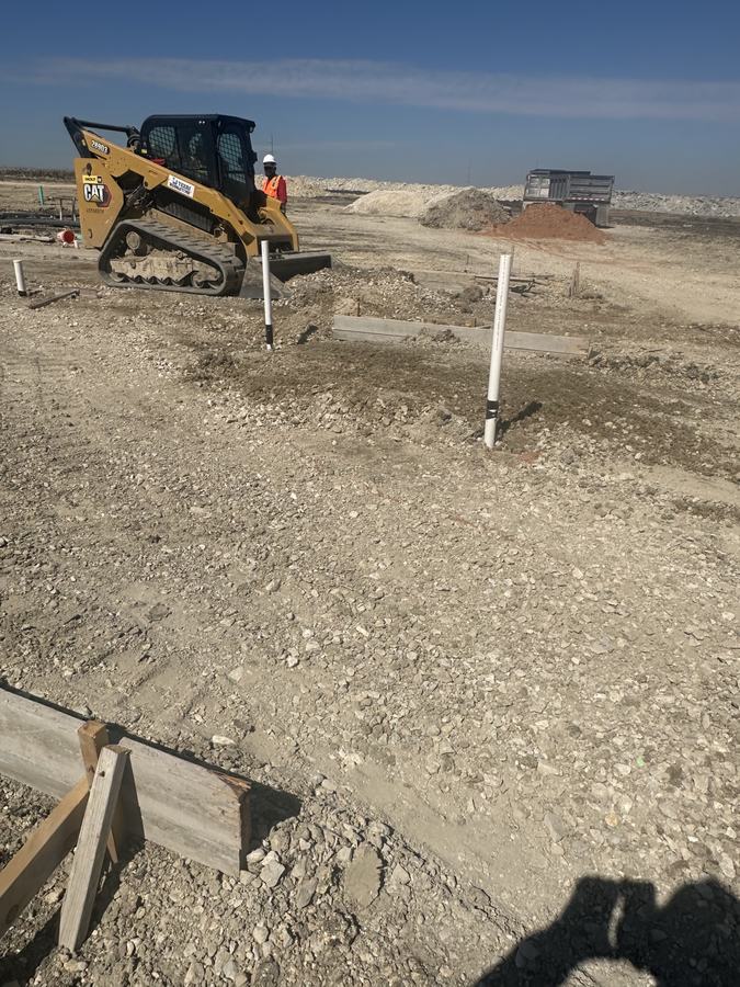 Skid Steer Backfilling the Pad