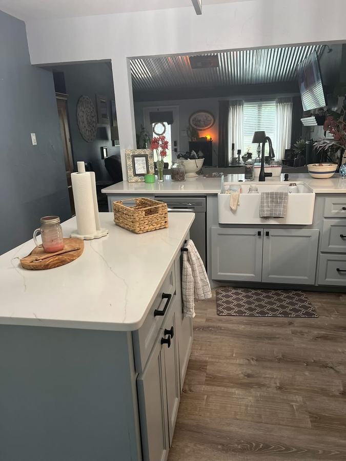 Remodeled kitchen island with quartz counter and farmhouse sink